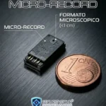 Microregistratore audio professionale Micro-Record di dimensioni inferiori a 1 cm (0,9 x 0,6 x 0,2 cm) confrontato con una moneta da 1 centesimo per evidenziarne la miniaturizzazione